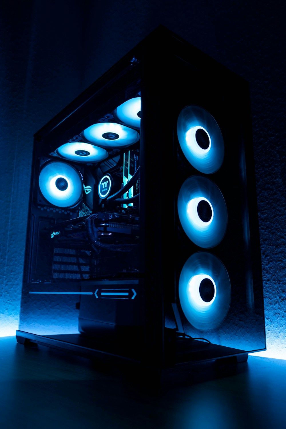 An illuminated custom desktop PC with blue cooling fans