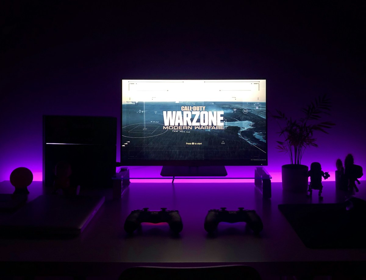 A gaming setup with purple lighting and a game on a monitor